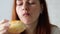 Caucasian young pretty woman enjoying while eating donut. Hungry woman, close up