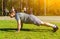 Caucasian young sportsman doing exercise plank on outstretched arms or performing push-ups