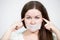 Caucasian young woman with glued tape on her mouth and closed ears, grey background