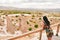 Caucasian young woman tourist on viewpoint watch three sister monument in Cappadocia