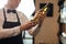 Caucasin elegant male sommelier with wine bottle near rack at wine store