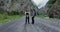 The Caucasus. A couple of hikers stands on road among rocks and looks at camera