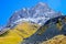 Caucasus mountains in summer, green mountains, snowy Peak Chiukhebi and blue sky