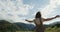 The Caucasus. A young woman dances on road near cows pasture between mountains