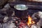 Cauldron boils on the fire in the forest. In marching a saucepan preparing food. Adventure tourism, camping, cooking on a fire