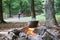 A cauldron with food at the fire and children playing badminton