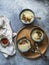 Cauliflower cream soup in three blue bowls, decorated with fried cauliflower inflorescence, red paprika powder and vintage spoons