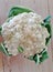 Cauliflower head. Organic cauliflower growing in summer with leaves