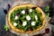 Cauliflower pizza crust with pesto, kale, mozzarella cheese and greens.