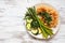 Cauliflower steak with grilled vegetables on a rustic white wood background