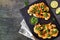 Cauliflower steaks top view scene on a dark background, healthy plant based meat substitute concept