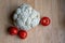 Cauliflower and tomatoes on a light wooden table