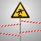 Caution, low-noticeable obstacle. Safety sign. Yellow triangle with black image on the pole and protecting ribbons. Gray