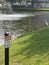 Caution open water sign by Lake with fountain and bird