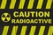 `Caution, radioactive` warning sign written in bold letters with radiation symbol and yellow and black stripes