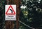 A `Caution Sharp Bend` sign hung up on a tree in the UK in a forest