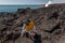 Caution sign on lava beds with bright red lava flow of volcano in Hawaii on coast