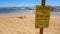 Caution sign with monk seal on beach