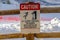 Caution sign on wooden fence against snow