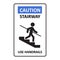 Caution stairway Use Handrails sign. A man goes down the stairs and holds on to the handrail. A sign warning of danger