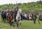 Cavalry soldiers ride on horses with naked swords