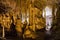 Cave dark interior with light, stalactites and stalagmites