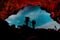 cave exit, silhouette of hikers at the cave looking at the night sky full of stars