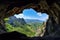 cave-in of a mountain with view of valley, surrounded by blue skies