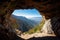 cave-in of a mountain with view of valley, surrounded by blue skies