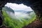 cave opening overlooking a foggy valley