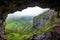 cave opening overlooking a foggy valley