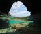 Cave on sea shore sky with clouds over under water