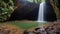 A cave with a waterfall and a pool of water