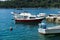 Cavtat / Croatia - 02 May 2019: Fishing village with small boats and an old man cleaning his fish of the day in the adriatic sea.