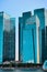 CBD or Central Business District buildings over Marina Bay waters in day light, Singapore. Vertical shot in cyan colors