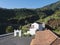 Cccc houses at village Las Nieves with green mountains and subtropical vegetation, blue sky background. La Palma, Canary