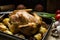 CCountry style roasted chicken on wood kitchen table, onions, scallions, potatoes, apples, hearty festive dinner