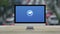 Cctv camera icon on desktop modern computer monitor screen on wooden table over blur of rush hour with cars and road in city,