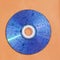 CD disk with water drops on shiny surface against orange background. Retro style and old technology  design