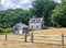 Cedar shake shingle barn and shed. In the foreground is a split-rail fence