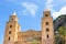 Cefalu Cathedral in Sicily, Italy with blue sky and rocks behind. Famous Roman Catholic basilica erected in Norman style