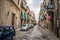 Cefalu old town narrow street view with cars parked and small balconies at the morning