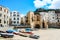 Cefalu, Sicily, Italy - Apr 7, 2019: Beautiful old harbor in small Sicilian city. Boats on a sandy beach. Traditional houses,