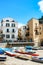 Cefalu, Sicily, Italy - Apr 7, 2019: Beautiful old harbor in the small Sicilian village. Fishermen boats on a sandy beach.