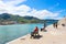 Cefalu, Sicily, Italy - April 7th 2019: People relaxing on the pier on Tyrrhenian coast in Sicilian city. Taken on a sunny day