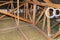 Ceiling and attic floor insulation made of rock wool between the trusses, visible ends of plastic pipes from ventilation.