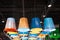 Ceiling lights under a dark ceiling made of colored zinc buckets painted in different colors