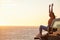 Celebrate alone if you have to. a young woman celebrating a personal victory while watching the sunset at the beach.