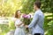 Celebrating anniversary. Loving young husband surprising his wife with flower bouquet outdoors