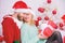 Celebrating christmas together. Loving couple cuddle smiling while unpacking gifts with christmas tree background